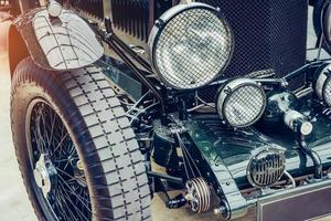 closeup of the headlights and front bumper on vintage automobile photo