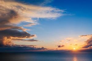 hermoso paisaje con puesta de sol sobre el mar foto