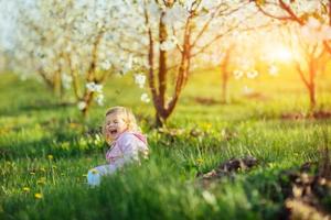 Child running outdoors blossom trees. photo