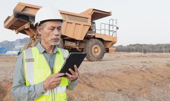Truck driver using tablet to inspect trucks, Asian elders
