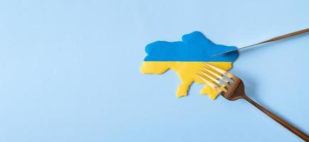 Yellow and blue Ukrainian map with fork and knife, top view. Banner with copy space photo