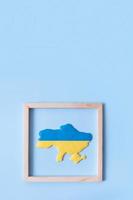 Map of Ukraine in yellow-blue colors of the Ukrainian flag in a wooden frame photo