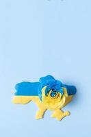 Map of Ukraine and a rose in the yellow-blue color of the national flag of Ukraine with copy space, top view photo