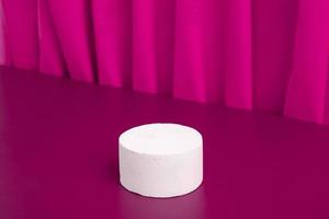 Podiums or pedestal Mock-up for cosmetic production on a pink background with folds of fabric. photo