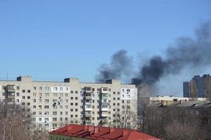 hay humo negro de la explosión de un cohete o una bomba en una ciudad durante una guerra foto