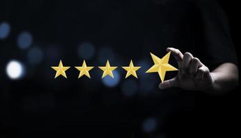 Businessman holding and input  yellow star to five stars for customer satisfaction after use product and service concept photo