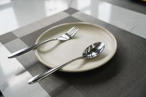 empty plate spoon and fork on table in restaurant. photo