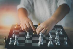 Little baby playing chess.Smart kid.fashion children. Little genius Child. Intelligent game.Chessboard. Baby activity concept. photo