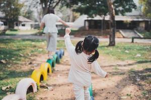 young asian mother playing with her baby on the playground. Mom and daughter. Cute baby daughter playing with mom happy funny family concept photo