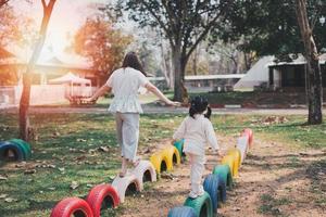 young asian mother playing with her baby on the playground. Mom and daughter. Cute baby daughter playing with mom happy funny family concept photo