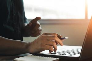 Close-up of a male hand holding a laptop, young man working at home using Laptop in work , Work at home concept. photo