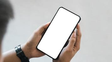 mockup copy space phone, man's hand holding smartphone with blank white copy screen for your advertising and message or information content, mobile on desk at coffee shop. photo