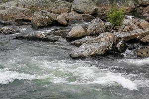 hermoso lago de río turquesa que fluye con piedras en hemsedal, noruega. foto