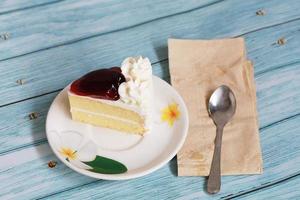 tarta de queso de arándanos sobre el postre casero de fondo azul con cuchara y papel tisú foto