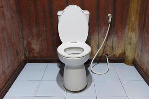 Toilet bowl with bidet shower in toilet. photo