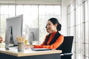 mujer asiática adulta joven que trabaja en la oficina el día foto