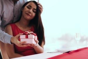 Closeup of present box holding hand by asian love couple man and woman on valentine theme photo