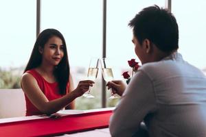 Smile asian lover couple man and woman hand hold a champagne drink and cheer. photo