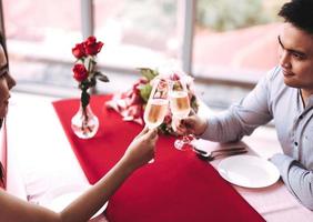 Smile asian lover couple man and woman hand hold a champagne drink and cheer. photo