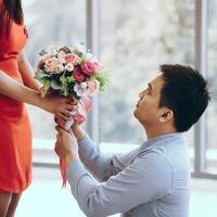 Adult asian man give a flower bouquet to girlfriend in romantic date. photo