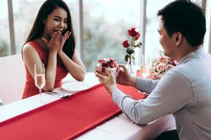 Man couple hand hold a romantic present red gift box give it to girlfriend. photo