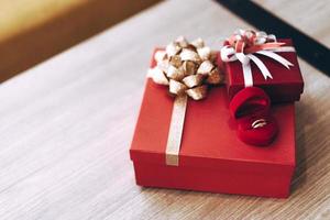 Wedding ring and red gift box on the table. photo