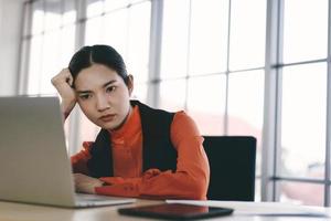 Mujer de negocios asiática estresada por el brote del virus covid 19 sobre las finanzas mundiales. foto