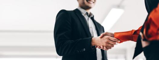 Asian adult business man and woman partner handshake together. photo