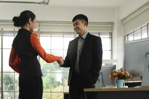 Asian adult business man and woman partner handshake together. photo