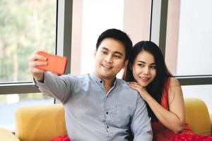selfie de pareja asiática con teléfono inteligente en casa. foto