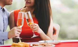 Smile asian lover couple man and woman hand hold a champagne drink and cheer. photo