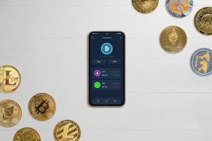 Phone with crypto wallet app concept on desk surrounded by crypto coins photo