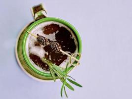 Warm strong alcohol cocktail with syrup with rosemary and bump on a top in the cup photo