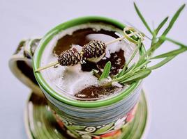 Warm strong alcohol cocktail with syrup with rosemary and bump on a top in the cup photo