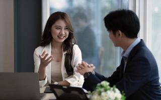 Group of young confident business people analyzing data using computer while spending time in the office photo