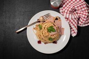pasta en plato blanco sobre fondo de madera comida italiana.