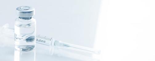 Medical syringe with a needle and a bollte with vaccine. photo