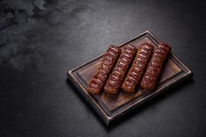 Grilled kebab with spices and herbs on a dark concrete background photo