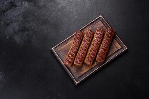 Grilled kebab with spices and herbs on a dark concrete background photo