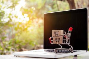Shopping online. cardboard box with a shopping cart logo in a trolley on laptop keyboard. Shopping service on The online web. offers home delivery photo
