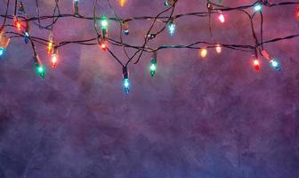 Christmas lights string on blue background with copy space photo