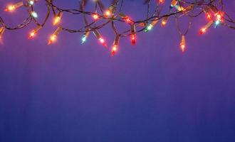 Christmas lights string on blue background with copy space photo