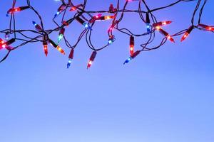 Christmas lights string on blue background with copy space photo