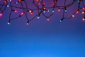 Cadena de luces de navidad sobre fondo azul con espacio de copia foto