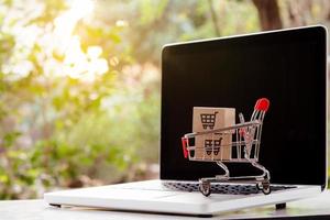 Shopping online. cardboard box with a shopping cart logo in a trolley on laptop keyboard. Shopping service on The online web. offers home delivery photo