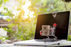 Shopping online. cardboard box with a shopping cart logo in a trolley on laptop keyboard. Shopping service on The online web. offers home delivery photo