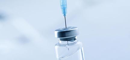Medical syringe with a needle and a bollte with vaccine. photo
