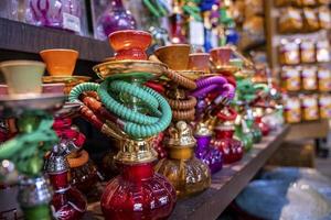 Various colorful hookahs display on souvenirs stand at market for sale photo