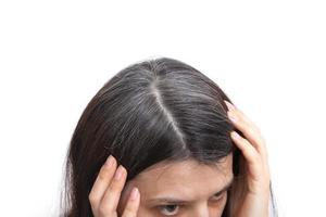 Head of a woman with graying hair on a white background. The concept of early gray hair photo