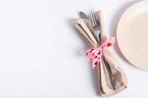 cutlery and a plate on the table with copy space. Serving for a romantic dinner on valentines day concept photo